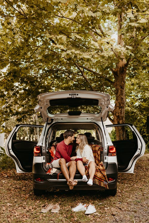 Couple sitting in the trunk of an SUV