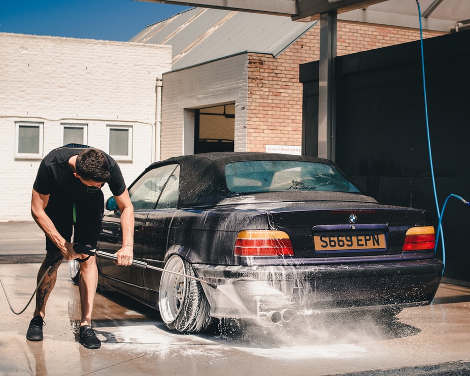 man washing car with car wash products