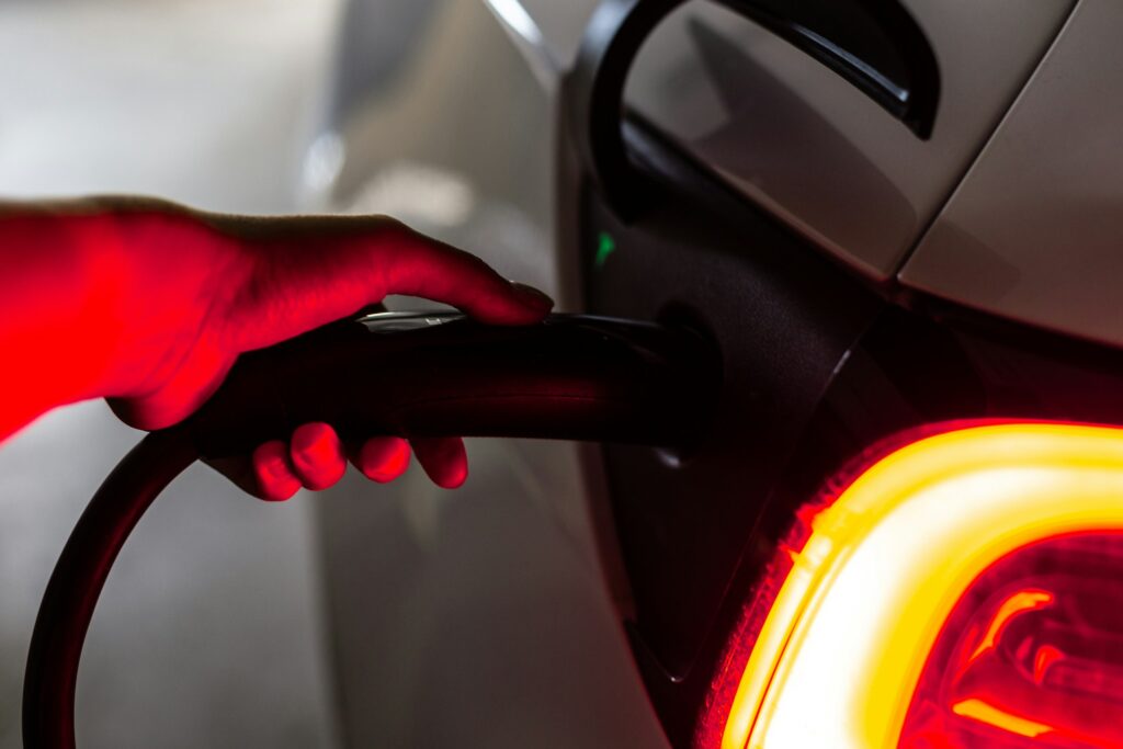 EV range anxiety, person charging white EV